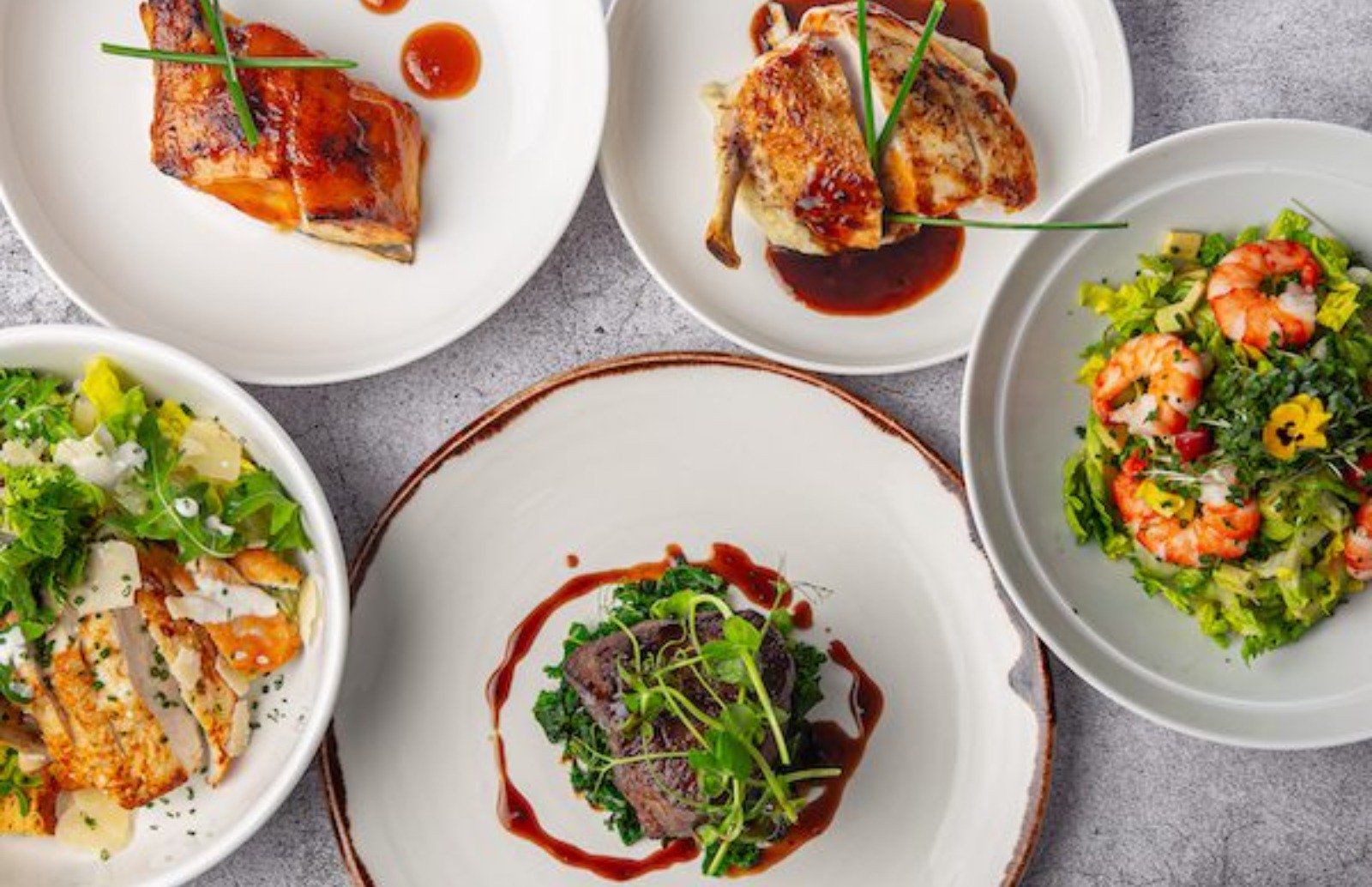 Overhead view of plates of food presented on white plates