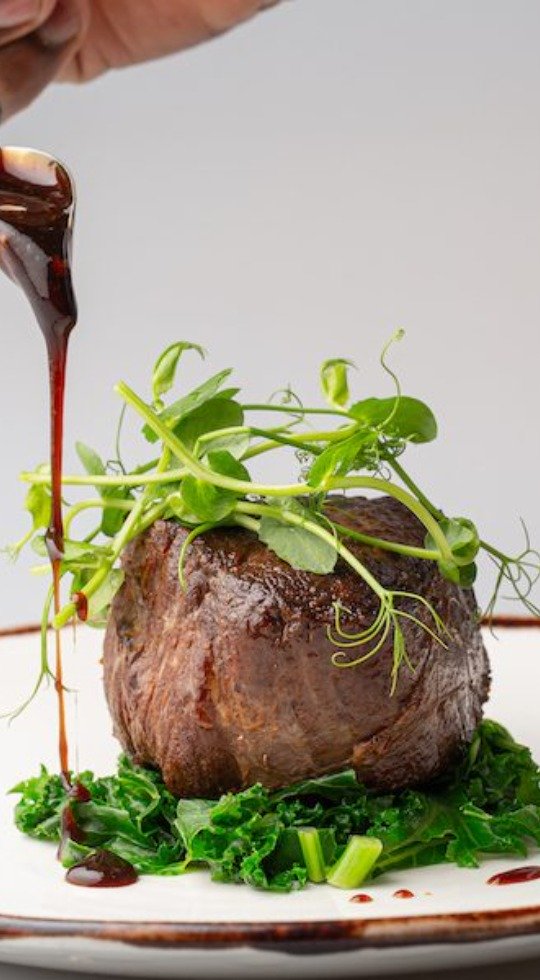 Premium in flight dining from 3Flavours Fillet steak drizzled with sauce, sat on wilted kale